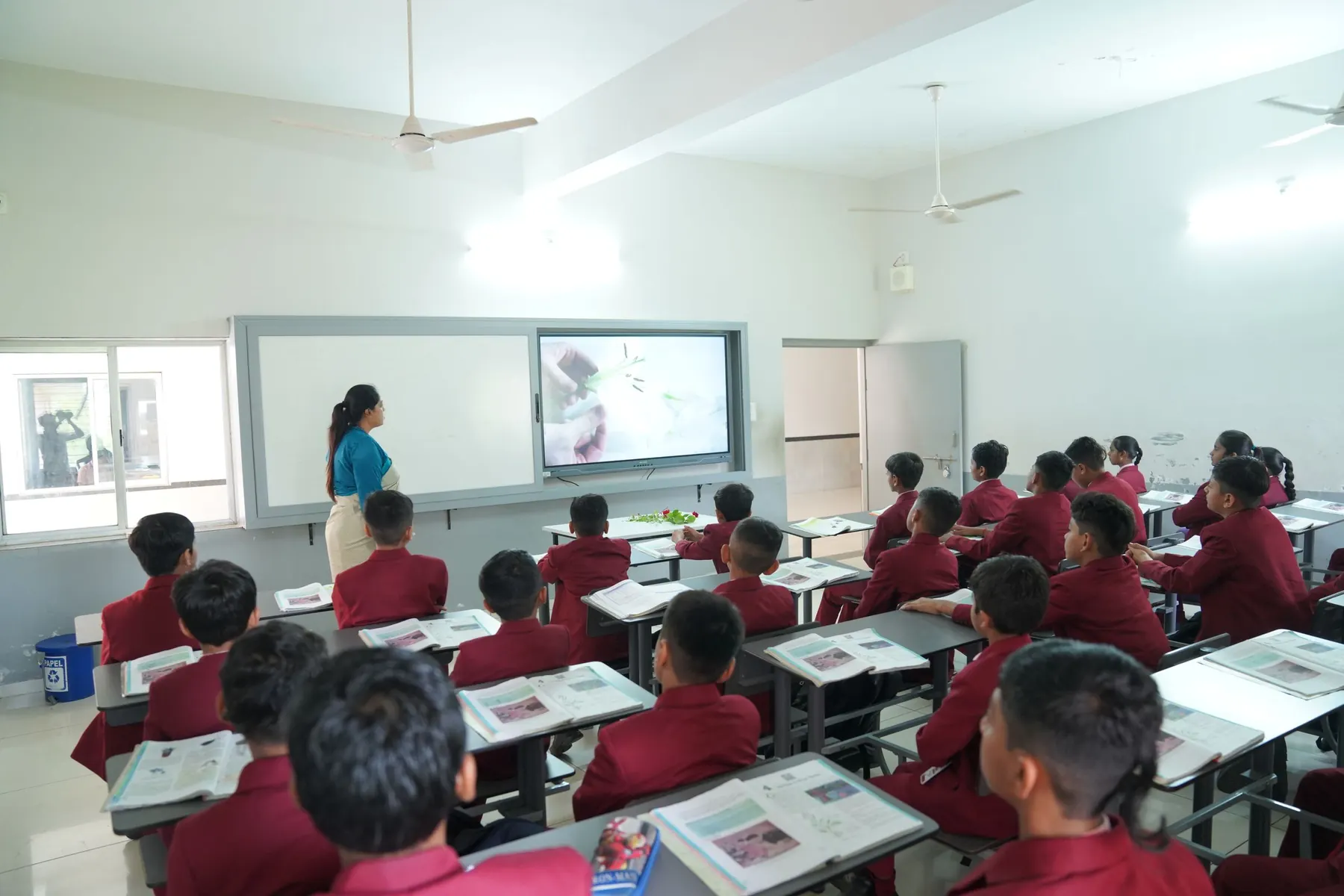 A teacher and students in a bright Indian classroom